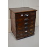 AN EARLY 20TH CENTURY STAINED WOOD BANK OF SIX DRAWERS, with foliate cup handles, width 45cm x depth