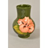 A SMALL MOORCROFT BULBOUS VASE, pink hibiscus flower on green ground, impressed marks to base,