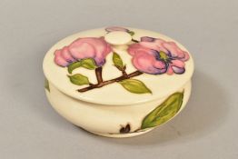 A MOORCROFT POTTERY POWDER BOWL AND COVER in the 'Magnolia' pattern on cream ground, impressed and