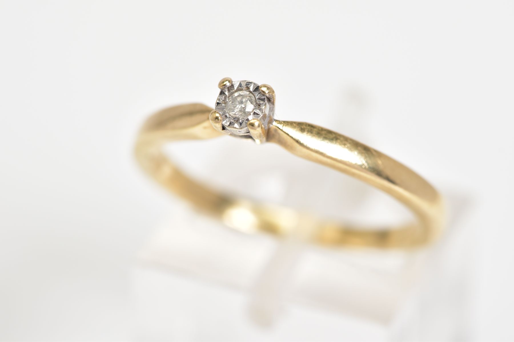 A 9CT GOLD SINGLE STONE DIAMOND RING, set with a round brilliant cut diamond within an illusion