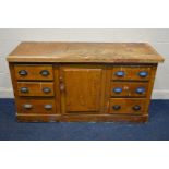 A VICTORIAN SCUMBLED PINE SIDEBOARD, with six drawers flanking a single cupboard door,with cupped