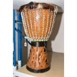 NATIVE ART INTEREST, a carved drum covered with deer skin, having handles and carved base,