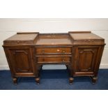 AN EARLY 20TH CENTURY OAK PEDESTAL SIDEBOARD, with a carved raised back, the two pedestals with