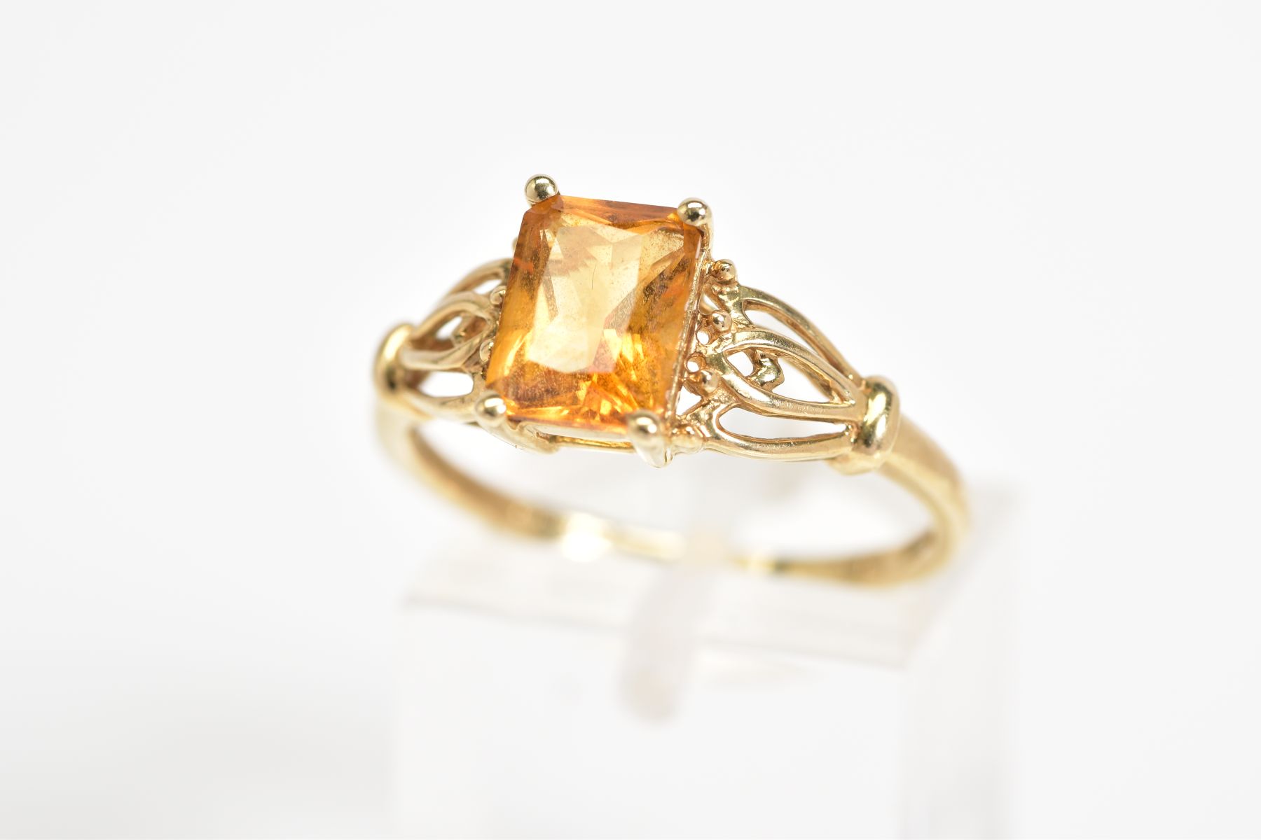 A 9CT GOLD CITRINE RING, designed with a central rectangular cut citrine, within a four claw