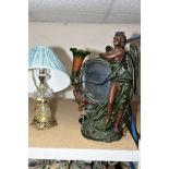 A PAINTED DISC MIRROR AND LIGHT TABLE LAMP, the mirror being held by angel and cherub, having