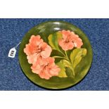 A MOORCROFT HIBISCUS PATTERN CABINET PLATE, on green ground, initials WM to back with faint 'Made in