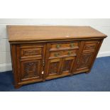 AN EDWARDIAN OAK PANELLED FOUR DOOR SIDEBOARD with two central drawers, width 150cm x depth 47cm x