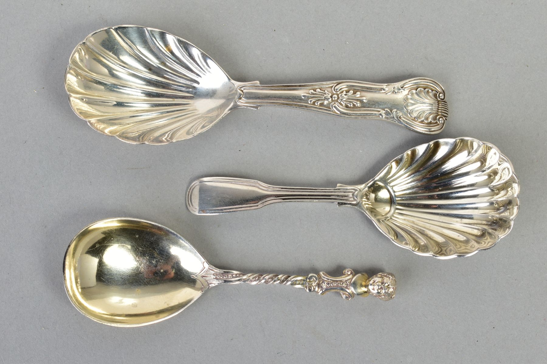 THREE SILVER CADDY SPOONS, to include a Victorian spoon with a cherub to the end of the handle and a