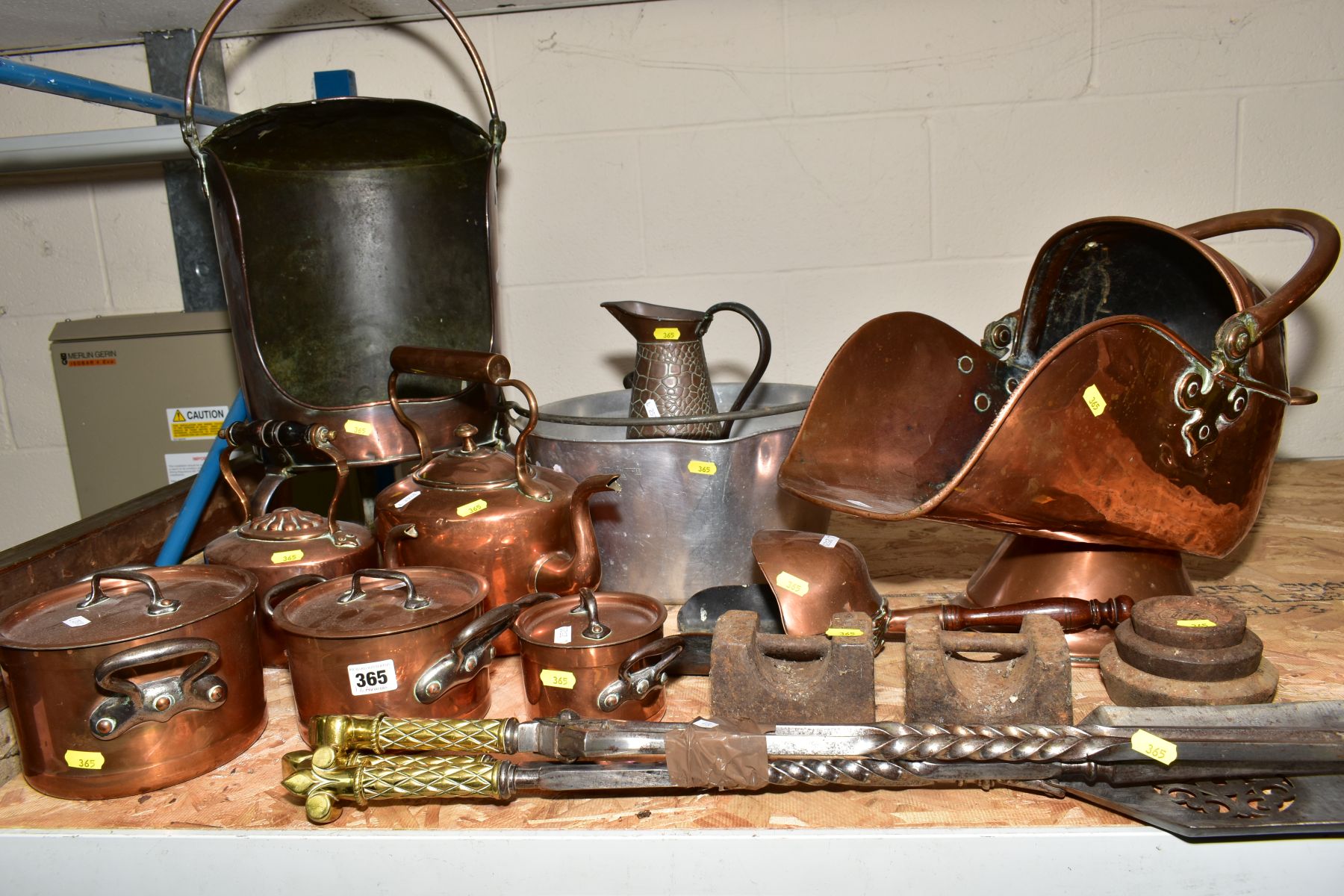 A GROUP OF METALWARE, comprising of three graduated twin handled copper pans with covers, two copper