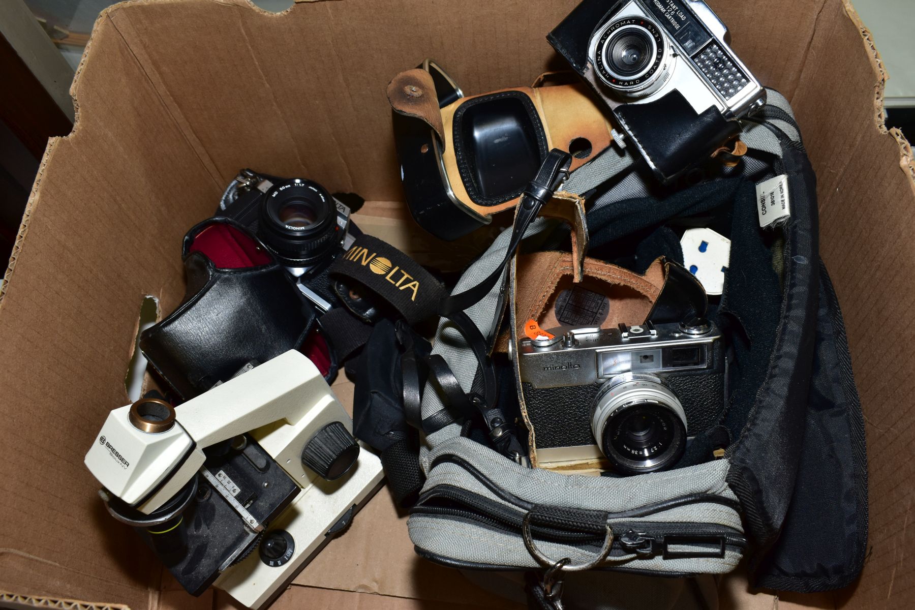 A TRAY OF CAMERAS AND OPTICAL ITEMS, including a Bresser microscope, a Minolta AL-F fitted with a