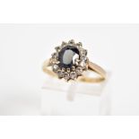 A 9CT GOLD CLUSTER RING, set with a central oval cut sapphire with a cut cubic zirconia surround, to
