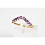 A 9CT GOLD AMETHYST SET RING, of V shape design set with nine circular cut amethyst, to the plain