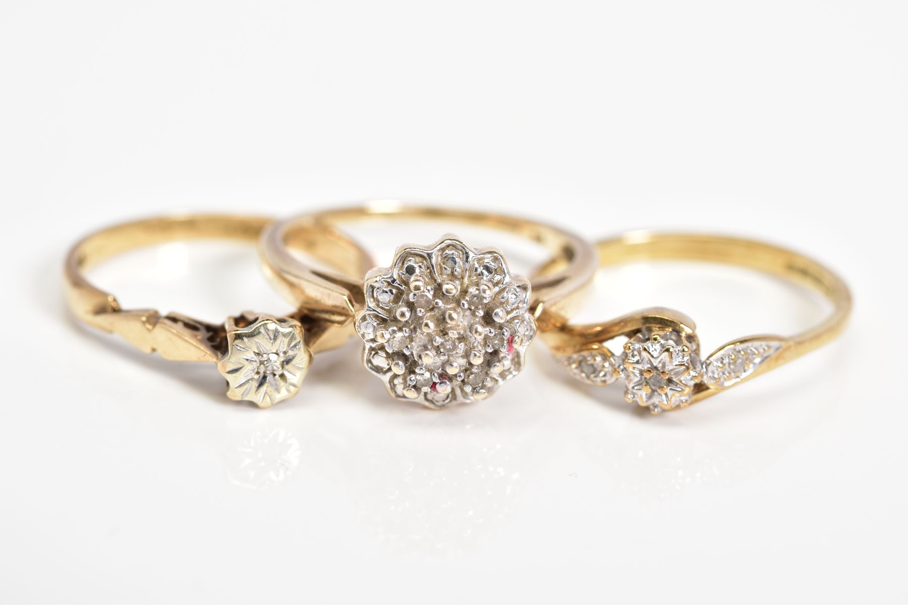 THREE 9CT GOLD DIAMOND SET RINGS, to include a raised single cut diamond cluster ring, stamped