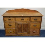 A VICTORIAN PITCH PINE SIDEBOARD, with a shaped back, seven assorted drawers with cupped handles