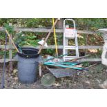 A COLLECTION OF VINTAGE GARDEN TOOLS, including a plastic dustbin, a wheelbarrow, rakes, spades,