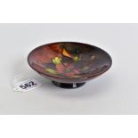 A MOORCROFT POTTERY FLAMBE PIN DISH, Columbine design to centre, on a circular foot, restoration