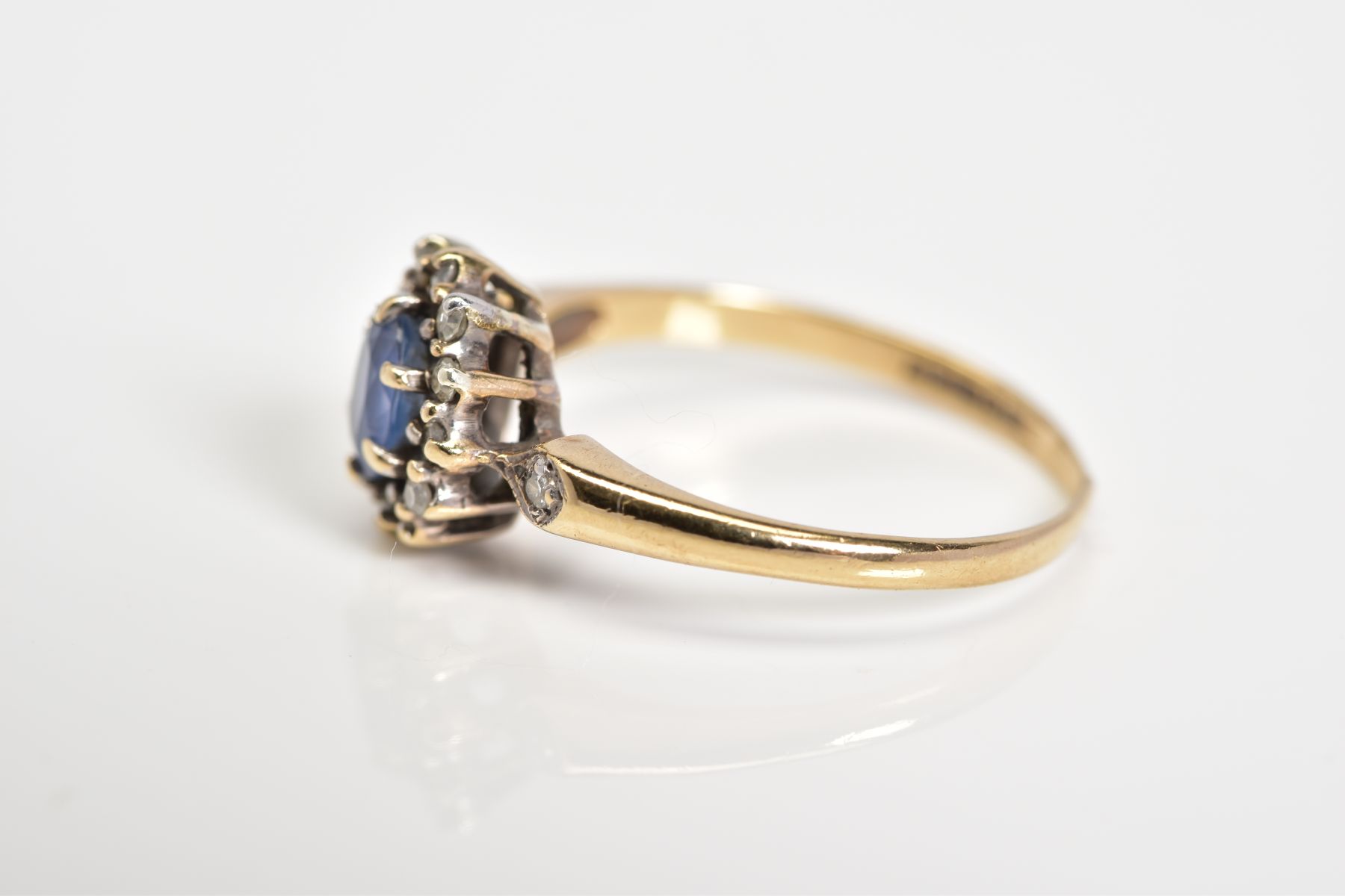 A 9CT GOLD CLUSTER RING, set with a central oval cut sapphire, single cut diamond surround to the - Image 2 of 3