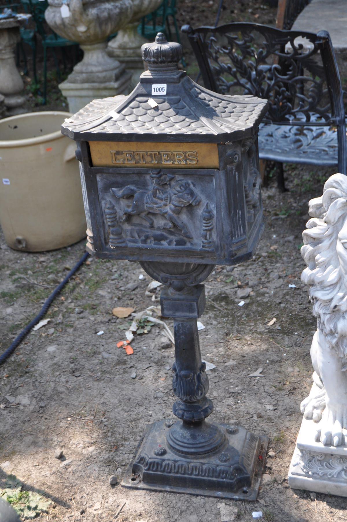 A MODERN CAST IRON POST BOX, with Chinese pagoda style roof, horse and rider detail to casting on