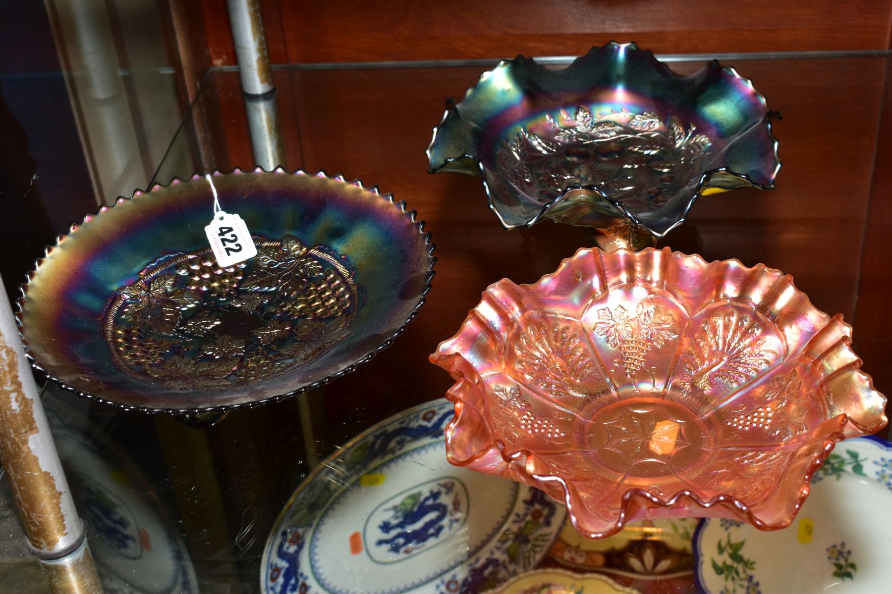 TWO PURPLE CARNIVAL GLASS FOOTED DISHES, one with grape decoration, approximate diameter 23cm and