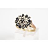 A 9CT GOLD CLUSTER RING, a three tiered cluster design set with a central circular cut sapphire,