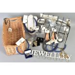 A BASKET AND DISPLAY STAND OF COSTUME JEWELLERY, the wicker basket includes items such as a