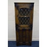 A REPRODUCTION OAK LEAD GLAZED SINGLE DOOR CORNER CUPBOARD, above double cupboard doors, approximate