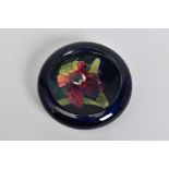 A MOORCROFT POTTERY CIRCULAR TRINKET BOWL, dark blue ground with orchid design, impressed marks,