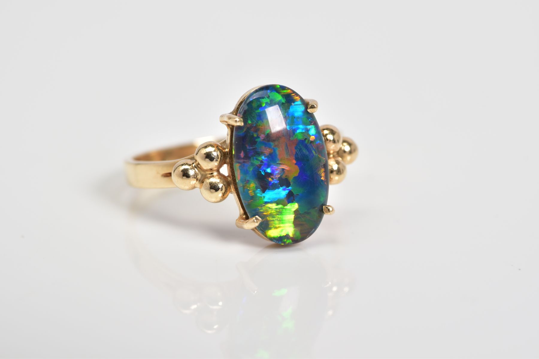 AN OPAL TRIPLET RING, the oval opal triplet set within a four claw setting, to the bead detail - Image 4 of 4