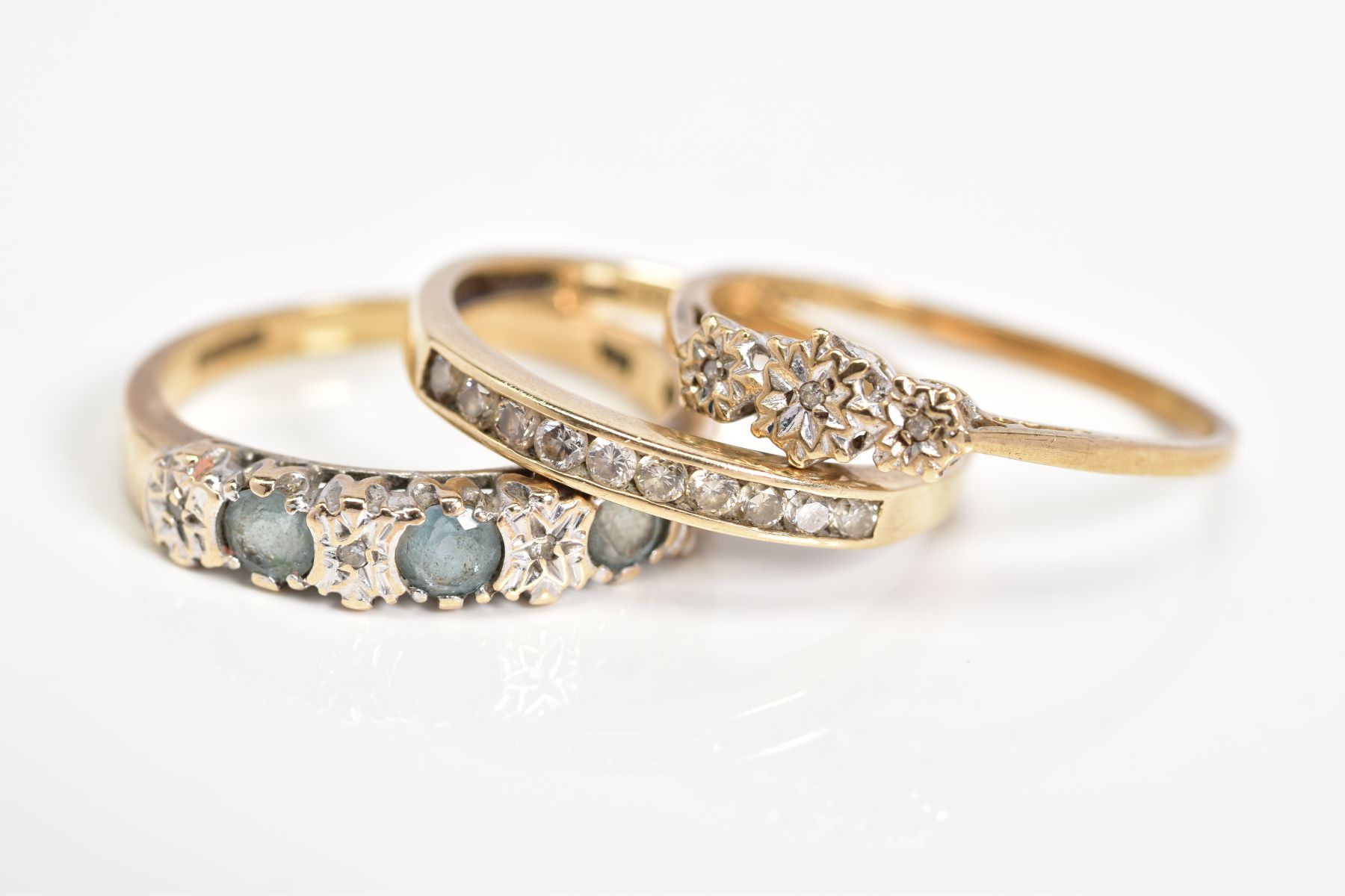 THREE 9CT GOLD GEM SET RINGS, the first a three stone single cut diamond ring within an illusion