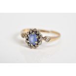 A 9CT GOLD CLUSTER RING, set with a central oval cut sapphire, single cut diamond surround to the