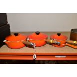 THREE LE CREUSET ORANGE ENAMEL SAUCEPANS AND LIDS, two 20cm and one 16cm and a Le Creuset frying pan