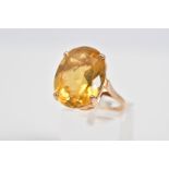 A LARGE CITRINE RING, set with a large oval cut citrine within a raised four claw setting, to the