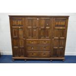 AN EARLY TO MID 20TH CENTURY LOW SOLID OAK COMPACTUM WARDROBE, comprising two panelled doors with
