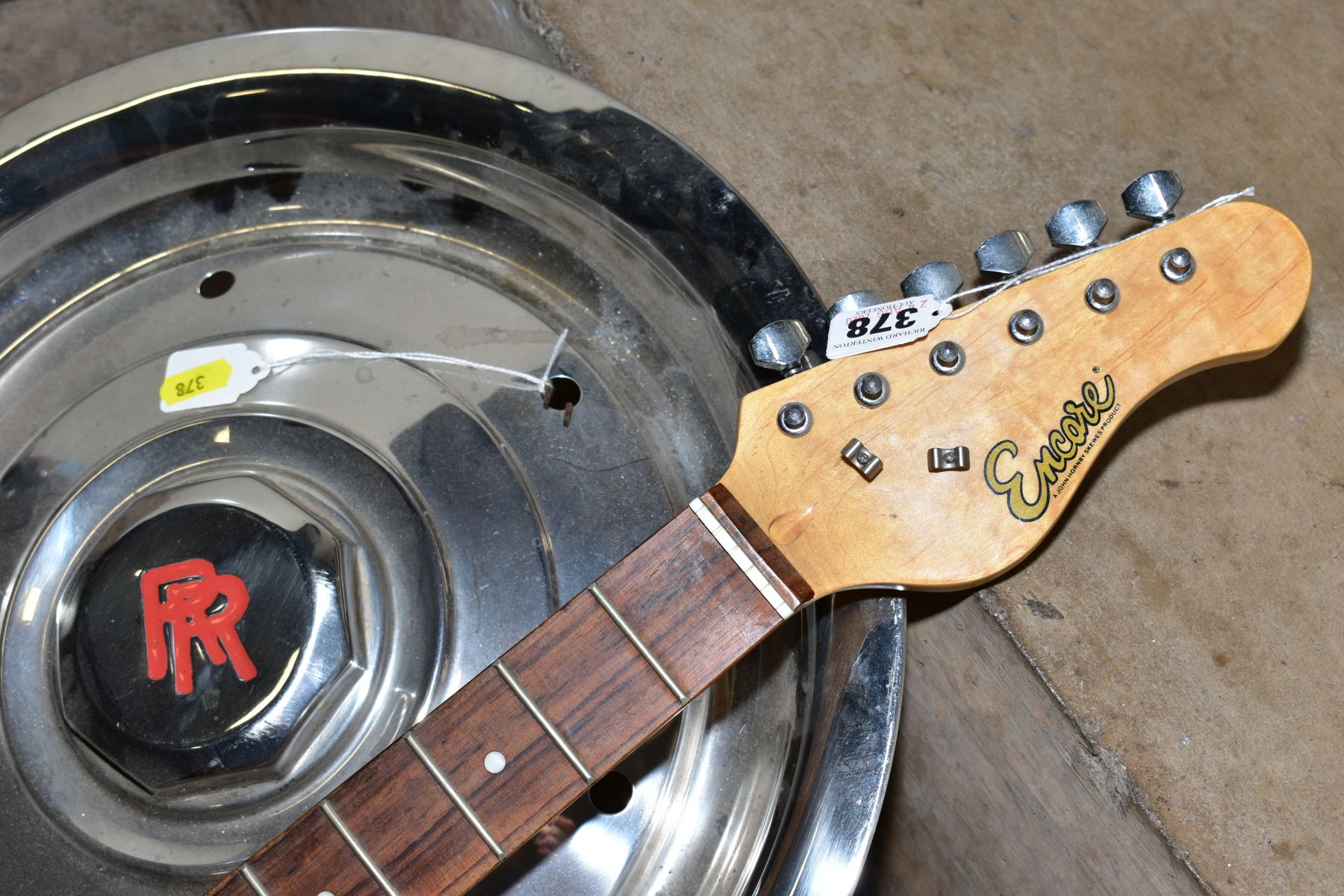 A ROLLS ROYCE HUB CAP AND AN ENCORE STRAT TYPE GUITAR, in black with white scratch plate, three - Image 2 of 2