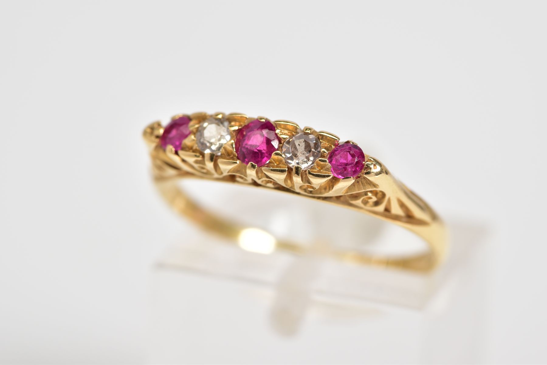 AN EARLY 20TH CENTURY 18CT GOLD RUBY AND DIAMOND RING, designed with three circular cut rubies
