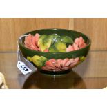 A MOORCROFT POTTERY FOOTED BOWL, 'Hibiscus' pattern on green ground, impressed backstamp and painted