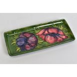 A MOORCROFT POTTERY RECTANGULAR TRINKET DISH, green ground with pink/purple anemone design,