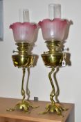 A PAIR OF ART NOUVEAU BRASS OIL LAMPS, clear glass chimneys (not a pair) with reproduction frilled