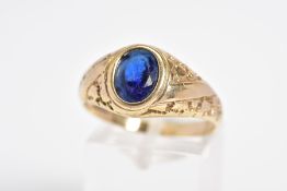 A 9CT GOLD GENTLEMENS SIGNET RING, designed with a central oval cut blue stone assessed as paste