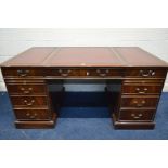 A REPRODUX MAHOGANY PEDESTAL DESK, the top with gilt tooled burgundy leather inlay, nine drawers and