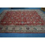 A 20TH CENTURY AGRA RED GROUND RUG, with multiple flower heads and fruiting vines and cream multi