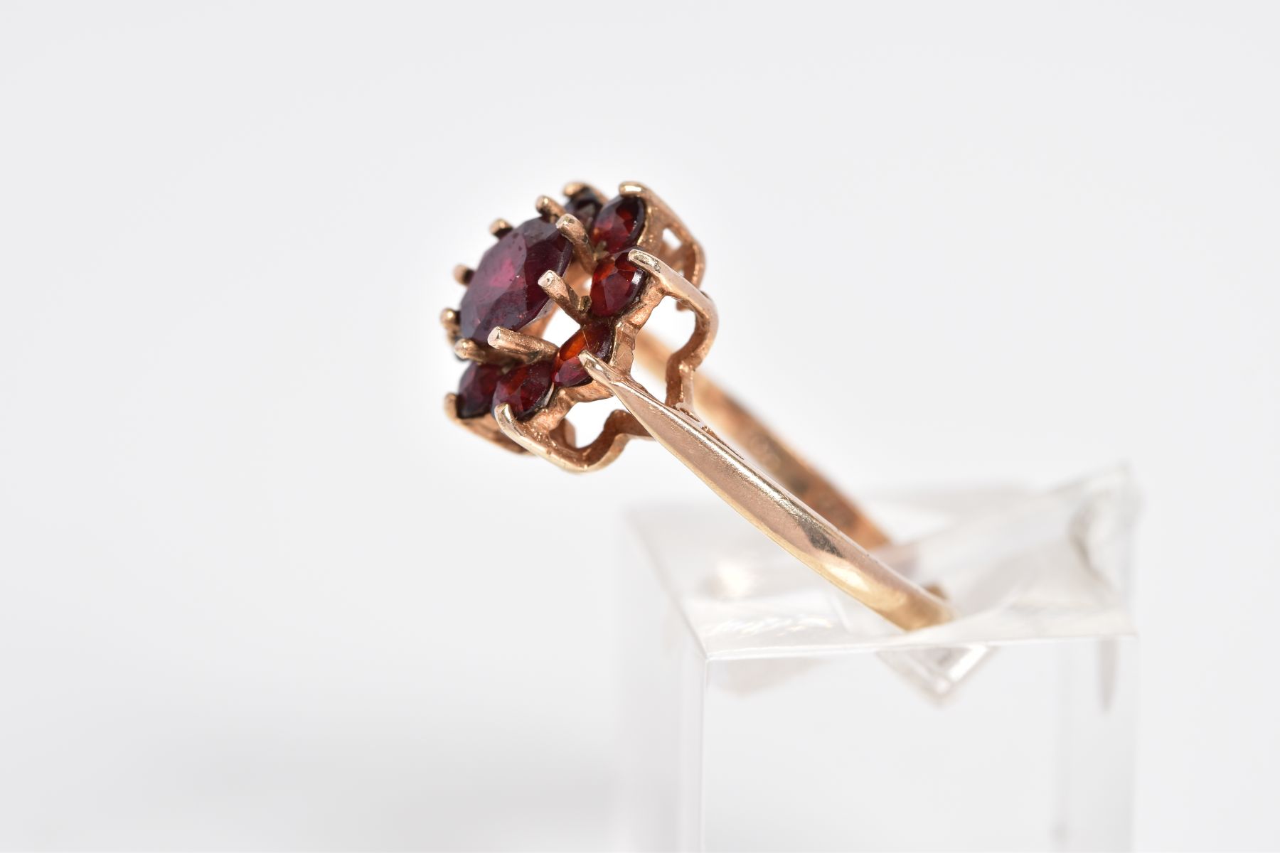 A GARNET CLUSTER RING, designed with a raised cluster set with nine circular cut garnets, to the - Image 2 of 3