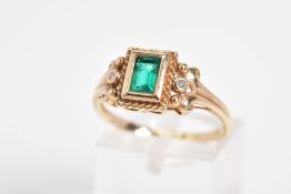 AN EMERALD AND DIAMOND RING, designed with a central rectangle cut emerald within a collet mount and