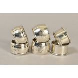 THREE PAIRS OF SILVER CIRCULAR NAPKIN RINGS, one pair engraved with monograms, another pair with
