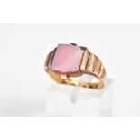 A 15CT GOLD SIGNET RING, designed with a carnelian square panel to the textured shoulders and