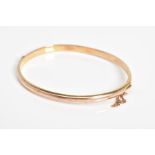 A 9CT GOLD HINGED BANGLE, the plain polished hollow bangle with push pin clasp and safety chain,
