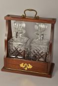 A TANTALUS, containing two cut glass decanters, with 'Total Service' plaque and carry handle,