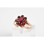 A GARNET CLUSTER RING, designed with a raised cluster set with nine circular cut garnets, to the