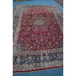 A 20TH CENTURY AXMINSTER RED AND BLUE GROUND RUG, floral design with central medallion and a multi