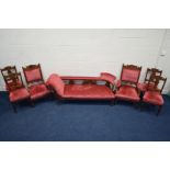 AN EDWARDIAN MAHOGANY SEVEN PIECE SALON SUITE, covered in pink draylon upholstery and foliate
